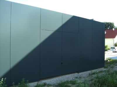 Flächenbündiges Schwingtor mit Fassadenplatten verkleidet